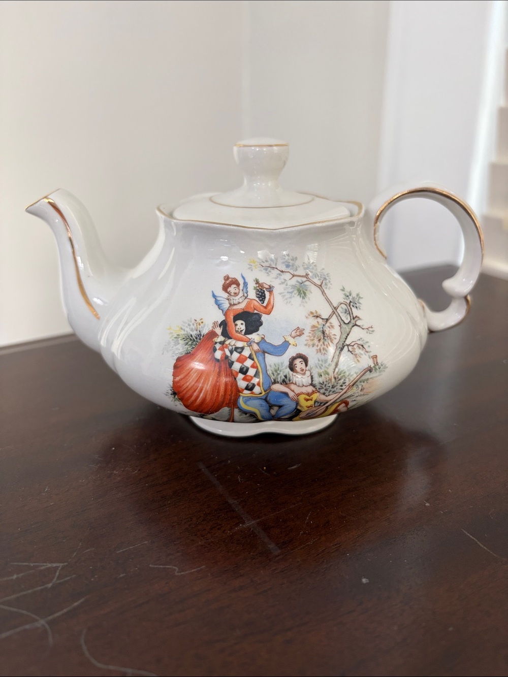 Vintage ceramic English teapot with transfer printer harlequin figures.